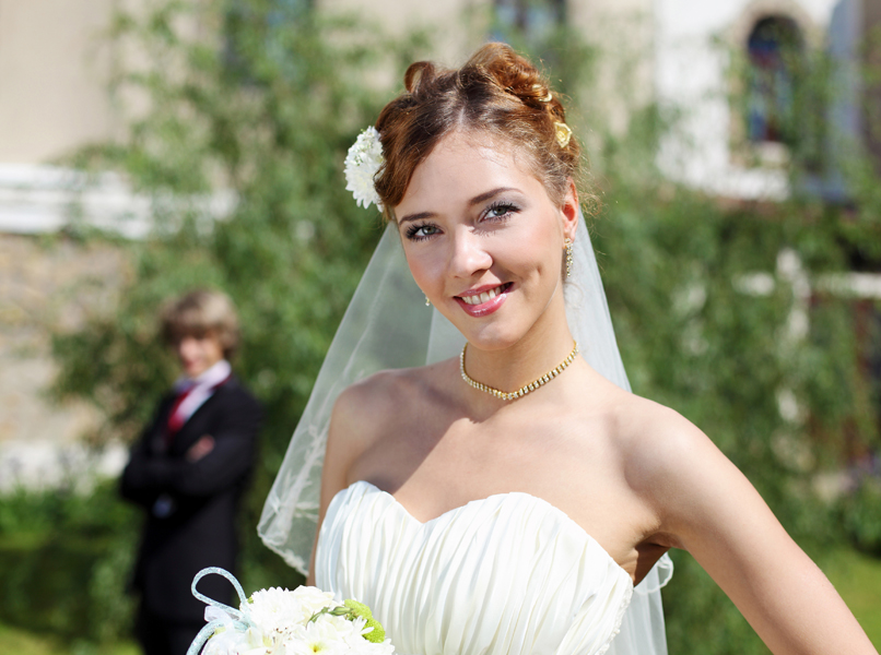 Braut im Kleid mit Braut- Strauß und Schleier